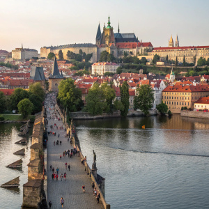 Historic scene of Charles Bridge in Prague. Prague Castle and St. Vitus Cathedral visible in the background. Serene river view, Czech Republic