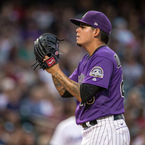 Anthony Banda, Hispanic baseball player, intense gaze. Purple and white pinstripe uniform. Focusing on his dark glove. Out of focus, cheering crowd in the background. Realistic photograph.