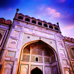 High-resolution image of Agra Fort's majestic gate. Intricate stone carvings, gold and grey accents. Ancient Indian architecture