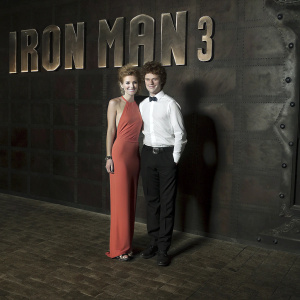 Bella Thorne and Remy Thorne attend 'Iron Man 3' premiere. Bella in eye-catching orange gown. Remy in crisp white shirt, black trousers. Red carpet, movie title backdrop, Hollywood