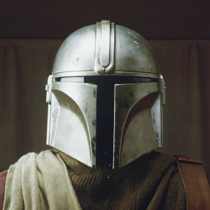Close-up of the Mandalorian helmet. The iconic helmet from Star Wars series. Positioned against a plain black backdrop