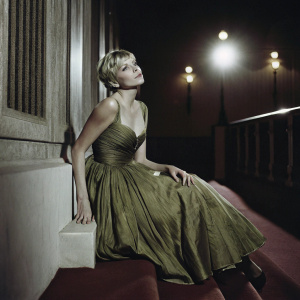 Michelle Williams in a green evening dress at the award show. Short blonde hair, elegant pose.