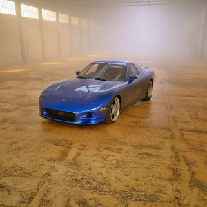 A stunning high-resolution image of a sleek blue mazda rx7 fd3s parked in a vast, empty garage. Its sharp front end, smooth body, and low profile are highlighted by the ambient lighting, creating a dramatic effect.