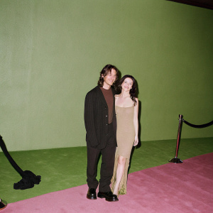 Clifton Collins Jr. and Francesca Eastwood, at the Hollywood premiere of 'Outlaws And Angels'. Clifton dons a black blazer, Francesca in a beige dress with a unique neckline. They pose together with warm smiles.