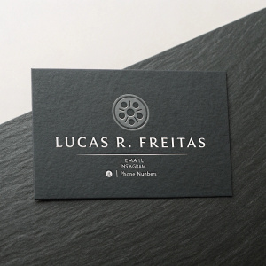 Professional business card for filmmaker Lucas R. Freitas. Dark grey background, embossed logo, and contact information including email, Instagram handle, and phone numbers.