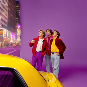 Jeff Conaway, Judd Hirsch, and Tony Danza, TV show Taxi cast. A bustling city street scene at night, with neon lights and crowds of people.