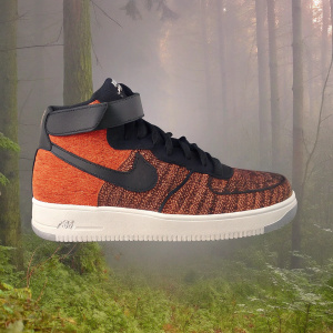 Digital art of Nike Air Force 1 sneaker. Dark gray backdrop. Shoe has black upper with red textured knit pattern. Includes black strap and white laces.