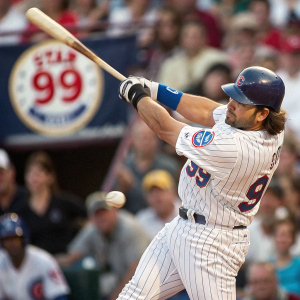 Close-up action shot of Mike Piazza in his batting stance. Star 99 Hookie logo visible. Crowd blurred in background. Sports action photograph.
