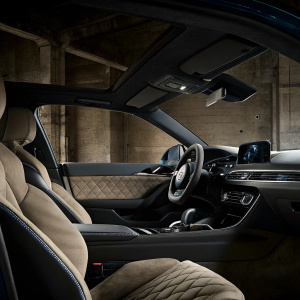 Inside a new Audi RS7 Sportback. Dark seats and sleek dashboard with futuristic controls and ambient lighting. Contemporary design with a focus on luxury and performance.