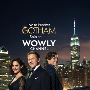 A promotional poster for 'Gotham' featuring cast members against a backdrop of a bustling city skyline at night. The actors are dressed elegantly, smiling. Text in Spanish reads: 'No te pierdas Gotham solo en Wowly Channel'