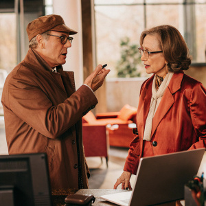James Spader and Susan Blommaert on the set of The Blacklist. Intense conversation in a modern office. No hospital bed