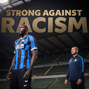 Romelu Lukaku featured in a powerful anti-racism campaign poster. Dressed in Inter Milan kit, he stands tall alongside a teammate. The backdrop is an empty stadium with 'Strong Against Racism'标语