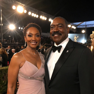 Clifton Powell and Kimberly at the SAG Awards, dressed in elegant gowns and tuxedos. Bright stage lights, crowd visible in the background.
