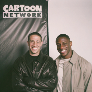 Stuart Snyder and Victor Cruz in a promotional shot for Cartoon Network. Both smiling warmly against a sleek black backdrop adorned with the network's logo. Stuart with a short, neatly styled haircut, Victor with a close-cropped cut.