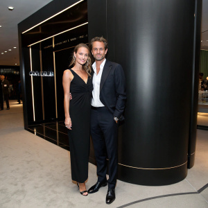 Giada Torri and Alexi Lubomirski at a chic indoor event. Posing in front of a sleek, modern, black backdrop.