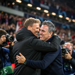 Julian Nagelsmann and Christophe Galtier sharing a hug post-match in a packed stadium. Fans with cameras document the moment.