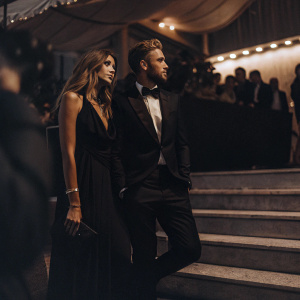 Stefanie Giesinger and Marcus Butler at the Venice Film Festival. Elegant black dress, sharp tuxedo, and a star-studded backdrop.
