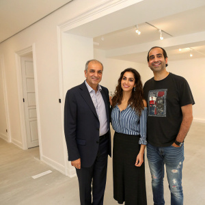 Gary Nader, Soraya Abu Naba'a, and an unknown man in graphic t-shirt. They are at a private event with an empty, white-walled room.