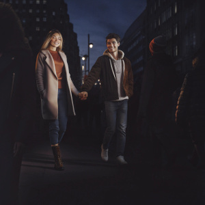 Gigi Hadid and Zayn Malik, casually walking down a busy street in London, surrounded by passerby and city lights