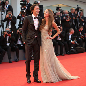 Adrien Brody and Lara Lieto at the Venice Film Festival, surrounded by flashing cameras and paparazzi.