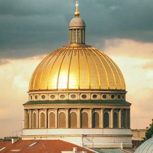 St. Stephen's Basilica in Budapest, Hungary at dusk. Majestic architecture, golden dome reflecting sunset light, partly cloudy sky