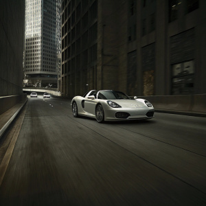 A pristine white Porsche 918 Spyder glides on a sleek, modern highway. Flanked by towering skyscrapers and other luxury vehicles. High-definition shot highlighting the car's unique aerodynamic design.