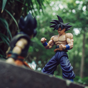 Son Goku action figure, detailed with realistic muscles, posed for action. White background, perfect for display.