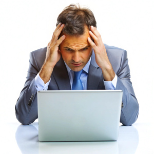 Stressed worker grabbing his head during work on laptop on white background