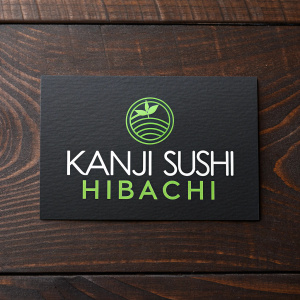 A modern business card for Kanji Sushi Hibachi. Dark wooden background. The card features stylized logo with green accents and text in sleek font.