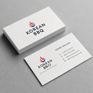 Modern and sleek business card design for a Korean BBQ restaurant. Clean white cards with minimalist text and subtle logo icons in vibrant colors. Set against a matte gray background.