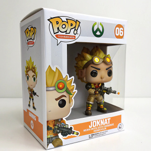 A Funko Pop! Games figurine of Junkrat from Overwatch. The toy stands ready for action. White cardboard box with colorful logos and character image on front.