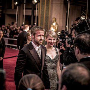 Michelle Williams and Ryan Gosling at the Academy Awards. They are dressed in elegant attire. Red carpet with paparazzi