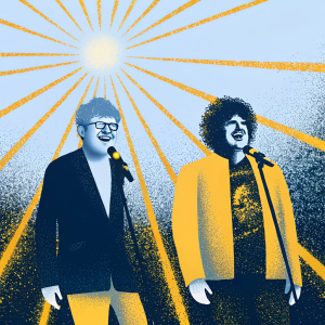 Ed Sheeran and Benny Blanco perform at the Grammy Awards. Ed, in a black suit and glasses, grins widely. Benny, with curly hair, sports a patch-covered jacket and graphic t-shirt. Behind them, a dazzling array of lights.