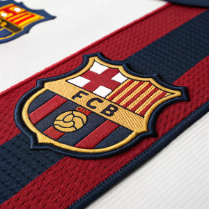 High-resolution image showcasing the FC Barcelona patch. Rich red color with bold design, featuring the club's emblem and logo. Made of textured athletic fabric with dark blue hues and intricate stitching.