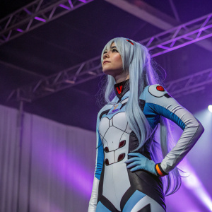 Cosplayer embodying Rei Ayanami from Evangelion at a convention. Dramatic lighting, purple gradient backdrop
