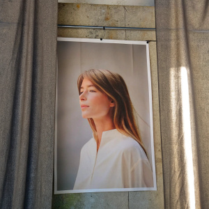 Francoise Hardy, with serene expression, in white blouse. Shot against a simple black backdrop, close-up style.