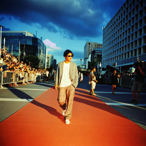 Joo Sang-Wook, Korean actor, in a casual outfit. Walking through a bustling street filled with fans and paparazzi.