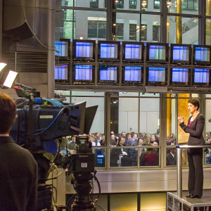 Rachel Maddow delivering a segment on MSNBC. Studio backdrop with large monitors displaying news content, blurred audience in background.