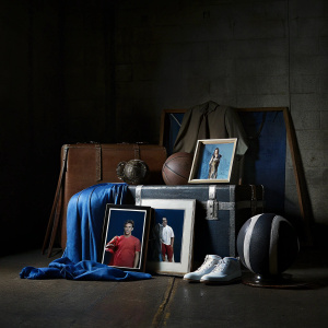 Cristiano Ronaldo's signed memorabilia collection. Various items like autographed balls, jerseys, and photos. Dark, moody background highlighting different poses and signatures.