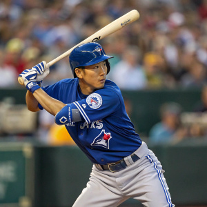 Munenori Kawasaki, Asian baseball player, in a batting stance. Blue jersey with number 66, gray pants, wooden bat. Blurred background of the stadium crowd.