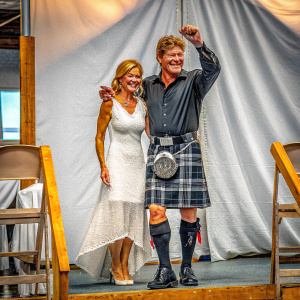 Hayley Roberts and David Hasselhoff on stage at the MTV European Music Awards. Glasgow, Scotland. Hayley in white dress, David in black kilt. Both smiling, against white backdrop.