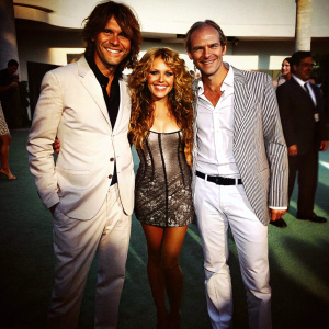Nicolas Vallejo Najera, Paulina Rubio, and Miguel Bosé at the Billboard Latin Music Awards, posing for the camera on a green carpeted floor.