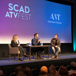 Panel discussion at SCAD aTVfest featuring Andra Reeve Rabb, Scott Foley, and Tom Verica. Bright stage lights, audience visible in the background.