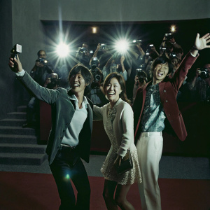 Celebrity trio Lee Chun-hee, Park Bo-young, and Lee Kwang-soo at a bustling movie premiere. Joyful expressions as they pose for numerous photographs.