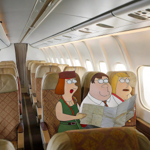 In a whimsical scene from Family Guy, Peter Griffin, Lois Griffin, Carol, and another woman are seated on an airplane. Peter, a hefty middle-aged man in a white shirt and green pants, Lois, an expressive woman with a map, Carol, and another woman in caps are all strapped in with seatbelts and by a window.
