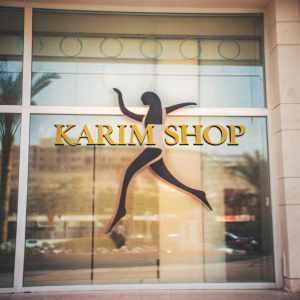 The KARIM Shop logo features a dynamic female silhouette in sleek motion. Bold, gilded letters spell out 'KARIM Shop'. The design floats against a clean white backdrop, highlighting the brand's spirit.