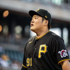 Ji Man Choi, Asian baseball player, intense expression. Wearing black Pittsburgh Pirates jersey with number 91. Stadium background blurred.