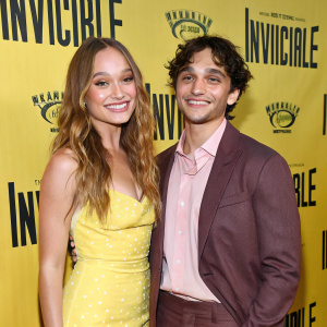 Maddie Ziegler, with auburn hair, and Jacob Villegas attending the Invincible musical premiere. Yellow background with event logos