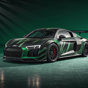 Custom painted Audi R8 in digital render. Black and green camo pattern. Prominent front grille, large wheels, rear wing. Dark green background with sharp lighting and shadows highlighting design details.
