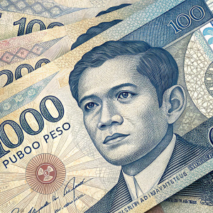 A close-up of Philippine banknotes. Various denominations, mostly 1000 peso bills, layered and overlapping each other. Blue, white, and beige color scheme with intricate patterns.